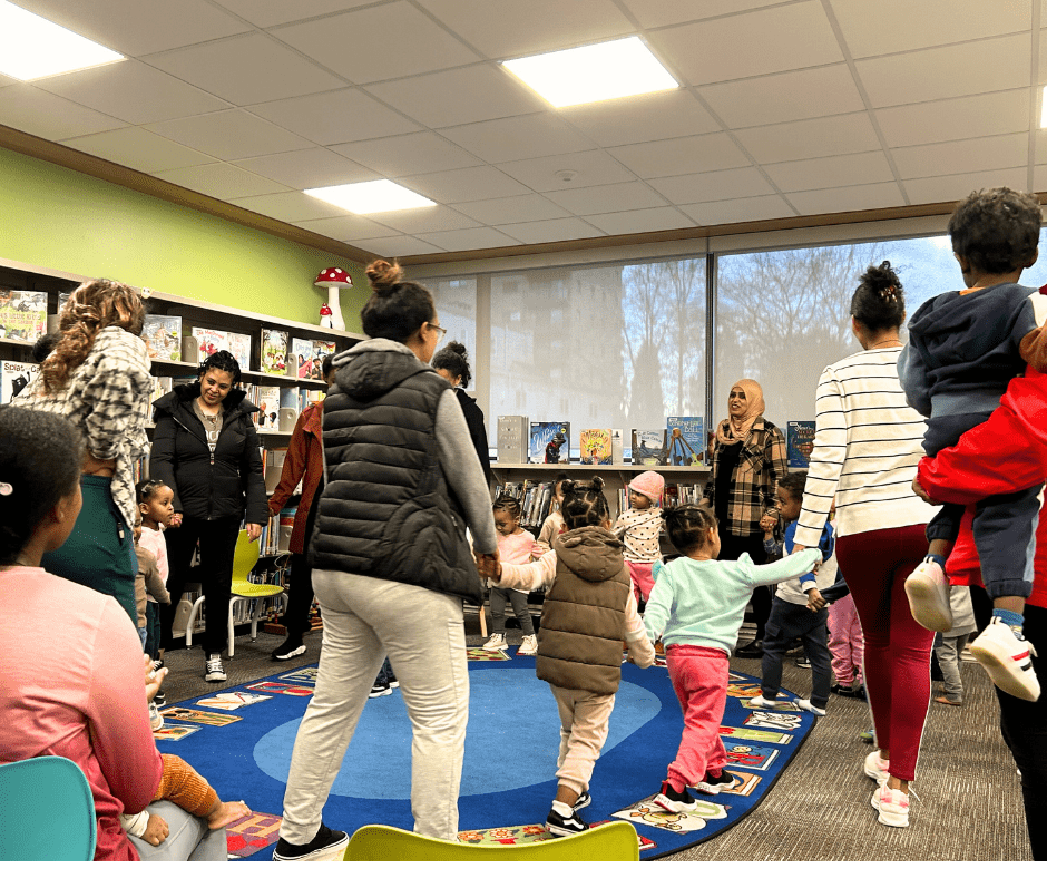Families hold hands and dance and sing songs in the Tigrinya language in the children's section at the New Westminster Public Library.
